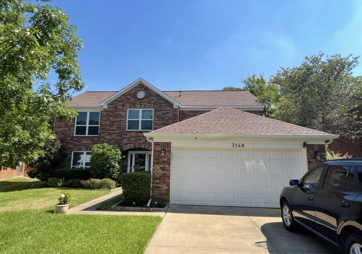 Finished two-story brick home with a hip garage roof.